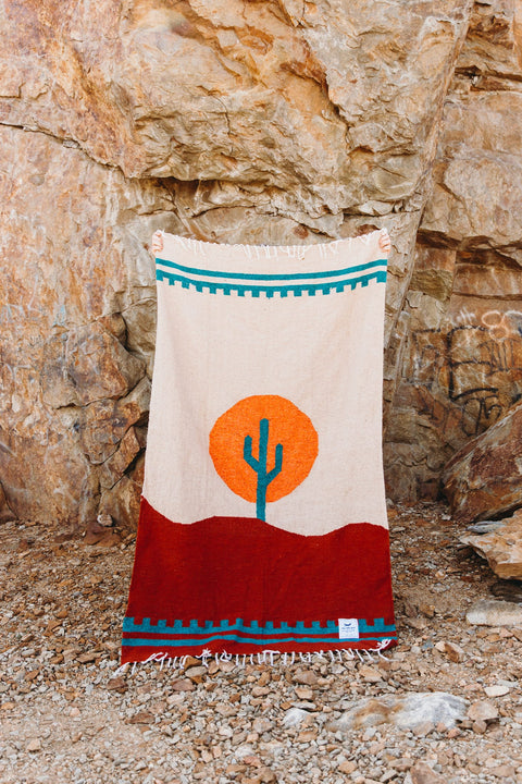 Cozy, versatile Arizona Blanket: handwoven from recycled clothing, featuring a cactus design in a beautiful desert sunset palette by Trek Light.
