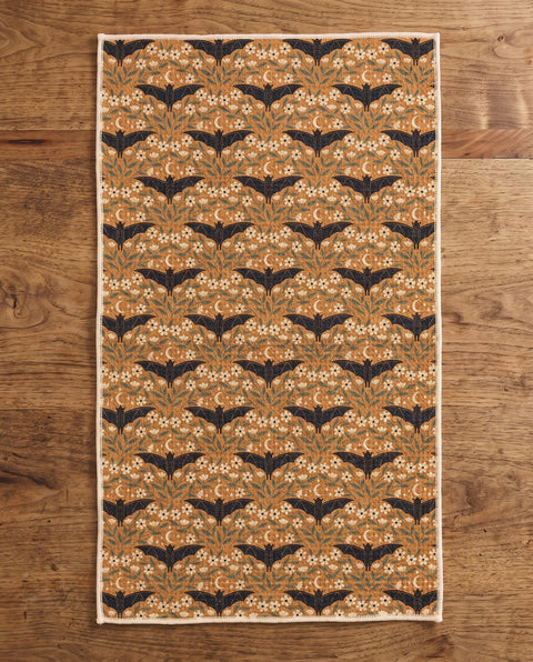 Bats & Blooms waffle kitchen tea towel reverse side laid flat: gold with navy bats and floral vines
