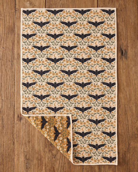 Bats & Blooms waffle kitchen tea towel flat lay with a corner folded up to reveal the reverse print