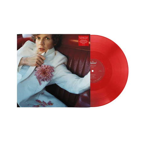 Red vinyl record with album cover featuring a person in a white suit with floral detail, laying on a red couch.