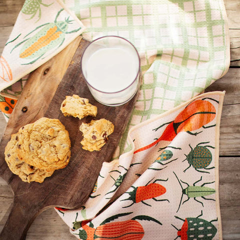 Beetlemania eco-friendly kitchen towel with beetle design, super absorbent, displayed with cookies and milk on wooden board.
