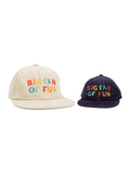 Matching adult and kids 'Big Fan Of Fun' hats in beige and navy for family adventures. Perfect twinsie set for fun-loving duos. By Trek Light.