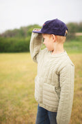 Child wearing a Big Fan Of Fun Kids Hat while standing on a grassy field, showcasing its playful design.