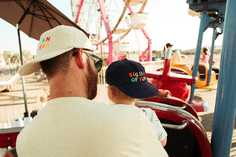 Big Fan Of Fun Hat - Twinsie Set worn by adult and child at amusement park, showcasing matching hats.