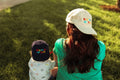 Big Fan Of Fun Hat - Twinsie Set featuring a parent and child in matching hats enjoying a sunny day outdoors.