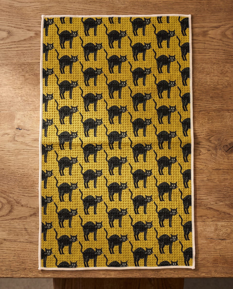 Black Cats waffle kitchen tea towel reverse side laid flat: mustard-yellow with black folk-art cats