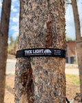 Black Double Hammock & Pro Hanging Straps, Butterfly Dreams Print, strap wrapped around a pine tree trunk outdoors.