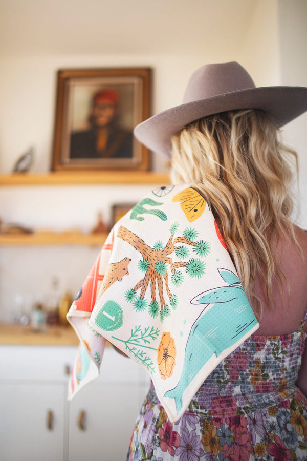 California Kitchen & Tea Towel with vibrant desert patterns on a woman's shoulder, showcasing style and functionality.