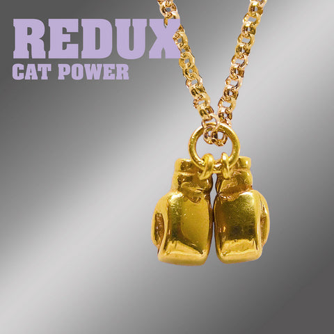 Gold boxing glove pendant necklace with 'Redux Cat Power' text in lavender on a gradient background.