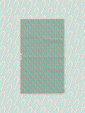 Candy cane print kitchen tea towel styled on a matching teal candy cane backdrop