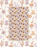 Cosmic Cowgirl Kitchen & Tea Towel with cowgirls, horses, cacti and clouds in purple and orange on cream