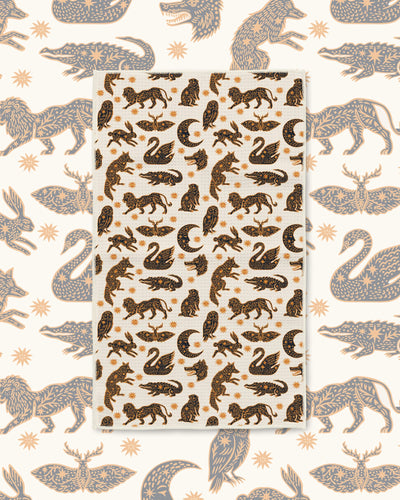 Cosmic Creatures Kitchen & Tea Towel with swans, prowling animals, moths and crescent moons in black and gold on cream