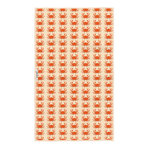 Reverse side of the crab kitchen tea towel showing smaller repeating orange crabs on cream fabric with a Trek Light woven