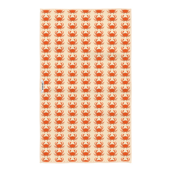 Reverse side of the crab kitchen tea towel showing smaller repeating orange crabs on cream fabric with a Trek Light woven