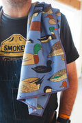 Ducks In A Row Kitchen & Tea Towel featuring colorful duck illustrations on a vibrant blue background.