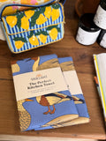 Ducks In A Row Kitchen & Tea Towel displayed on a wooden table with vibrant designs and packaging.