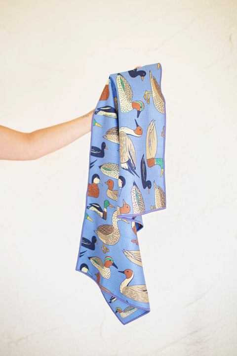 Ducks In A Row Kitchen & Tea Towel showcasing colorful duck designs on a blue fabric, perfect for kitchen use.