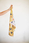 Farmhouse Chicken Kitchen & Tea Towel being held with colorful chicken design on a yellow background.