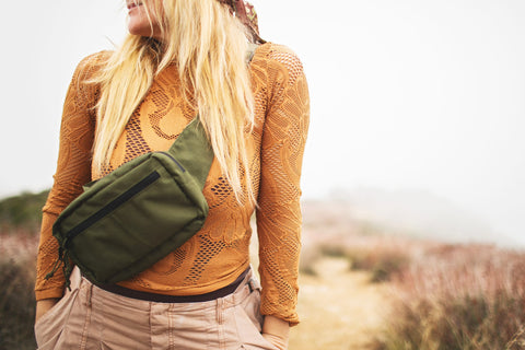 Everyday Fanny Pack (Fern) worn casually on a woman's torso, surrounded by outdoor scenery.