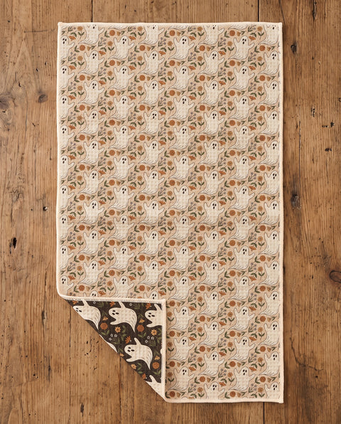 Ghost Garden kitchen tea towel flat lay with a corner folded up to reveal the dark reverse print