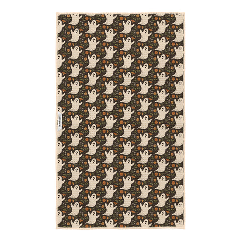 Reverse side of Ghost Garden tea towel on dark brown with cream ghosts, orange flowers and Trek Light woven tag