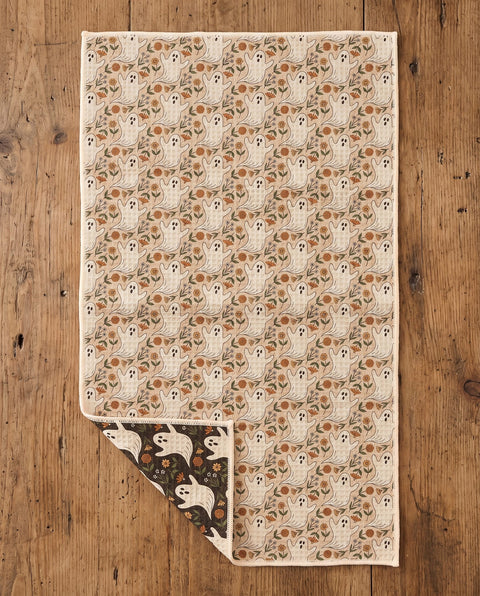 Ghost Garden kitchen tea towel flat lay with a corner folded up to reveal the dark reverse print