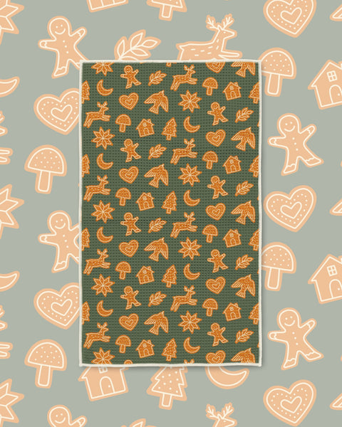 Gingerbread Kitchen & Tea Towel with orange gingerbread cookies, stars and moons on a dark green background