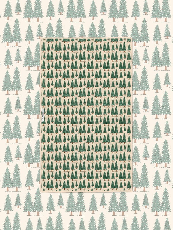 Gondola Winter tea towel laid over a matching cream ski resort pattern of mountains, gondolas, and pines