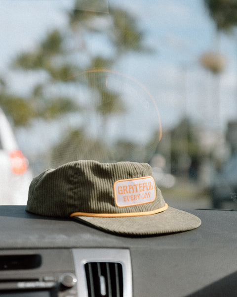 Grateful Every Day Hat displayed on a car dashboard, showcasing its stylish corduroy design.