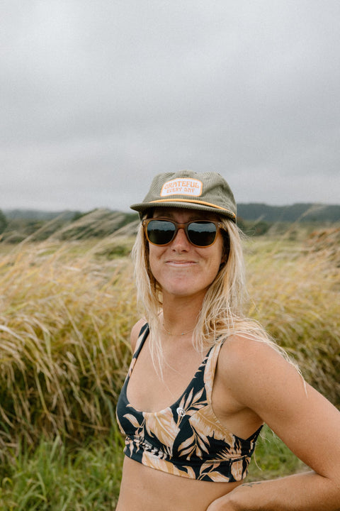 Woman in a Grateful Every Day hat enjoying a sunny day in nature, wearing Trek Light gear.