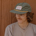 Man wearing Grateful Every Day hat by Trek Light, green corduroy snapback with flat brim, showcasing gratitude style.