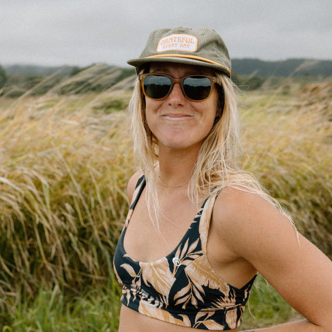 Woman in a Grateful Every Day hat enjoying a sunny day in nature, wearing Trek Light gear.