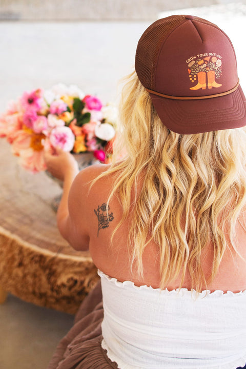Woman wearing a Grow Your Own Way Hat, stylishly designed with floral graphics and adjustable fit.