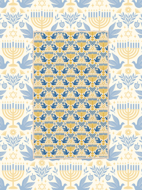 Gold and blue menorah, dove, and Star of David tea towel on cream Hanukkah-themed backdrop