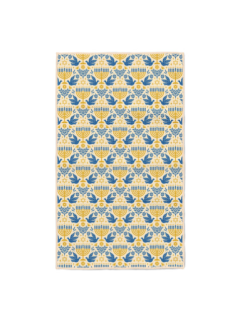 Cream kitchen towel with blue and gold menorahs, doves, and Star of David folk pattern for festive kitchens