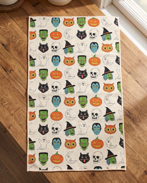 Happy Halloween waffle kitchen tea towel laid flat on a wood counter showing the full front print