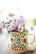 Honey Bee Enamel Mug 16oz filled with purple flowers, featuring a beautiful honey bee design.