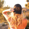 Woman wearing a Let's Get Weird Hat, showcasing its unique design against a sunny backdrop.