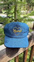 Mama Hat displayed on a wooden railing with greenery in the background, perfect gift for mothers.