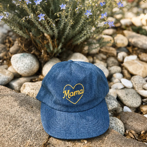 Mama Hat displayed on stones with flowers, showcasing its stylish and comfortable design.