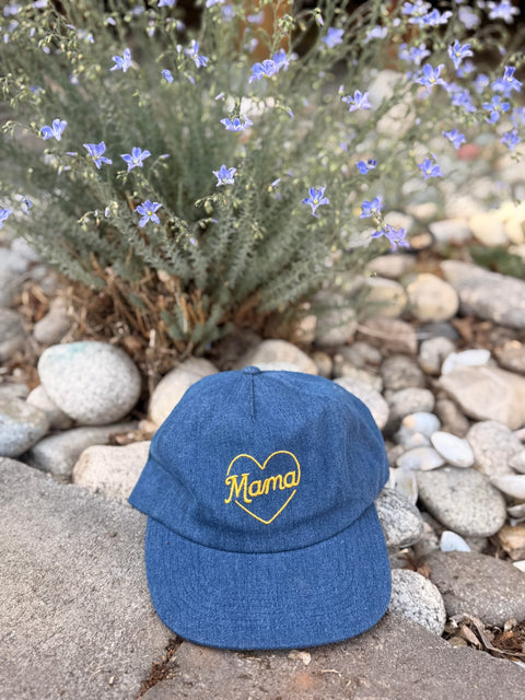 Mama Hat displayed on stones with flowers, showcasing its stylish and comfortable design.