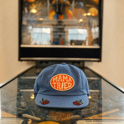 Mama Tried Hat displayed on a table with a vibrant background, showcasing its unique design and style.