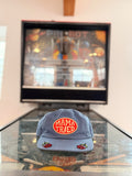 Mama Tried Hat displayed on a table with a vibrant background, showcasing its unique design and style.