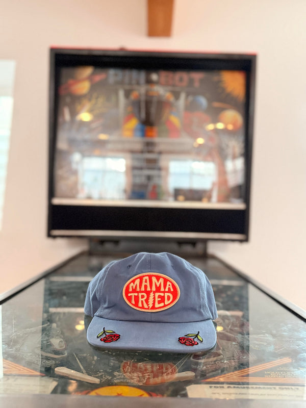 Mama Tried Hat displayed on a table with a vibrant background, showcasing its unique design and style.