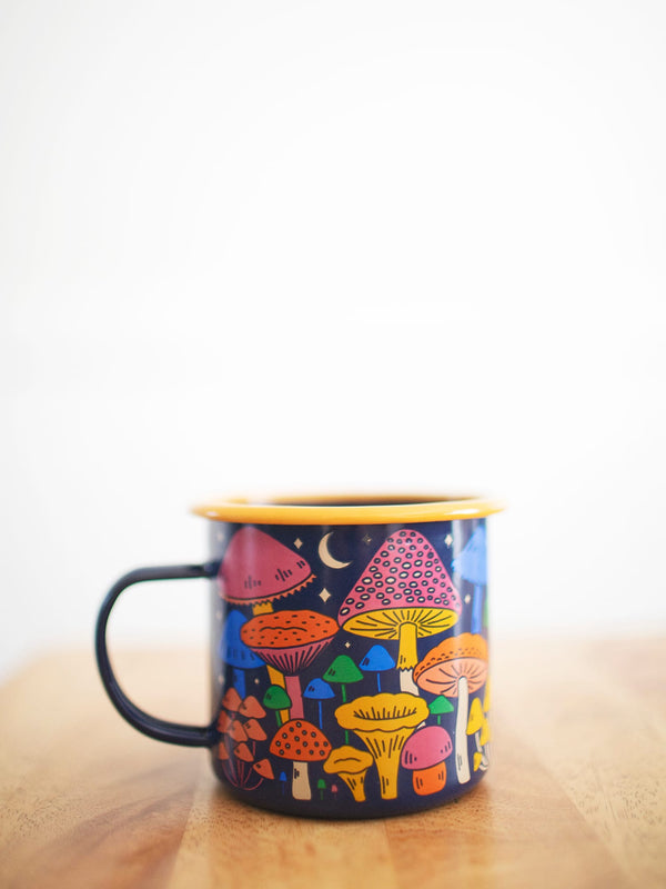 Midnight Mushroom Enamel Mug 16oz with colorful mushroom design by Trek Light on a wooden surface.