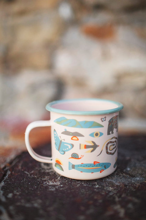 Mountain Stream Enamel Mug 16oz with colorful nature motifs, perfect for outdoor adventures or cozy mornings at home.