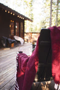 Napa Blanket draped over a chair with a glass of red wine, perfect for cozy evenings outdoors.