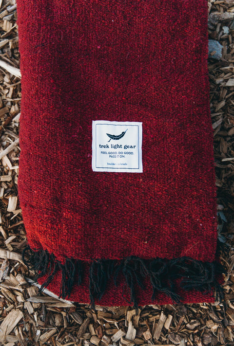 Cozy Trek Light Napa Blanket with rich red hue, made from recycled materials and handwoven for unique quality.