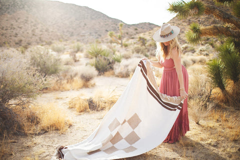 Beautiful handwoven North Star blanket in a desert setting, made from recycled clothing materials, showcasing its cozy versatility. By Trek Light.
