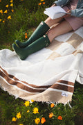 Cozy handwoven North Star blanket made from recycled clothing, showcasing beautiful natural tones. Perfect for outdoor relaxation. By Trek Light.